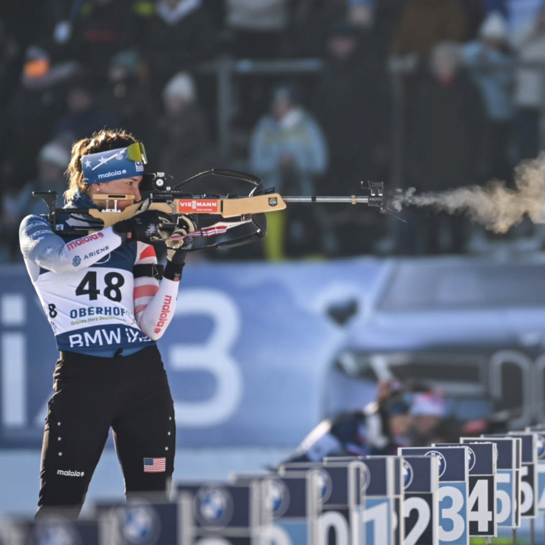 Biathlete aiming a rifle on a target range
