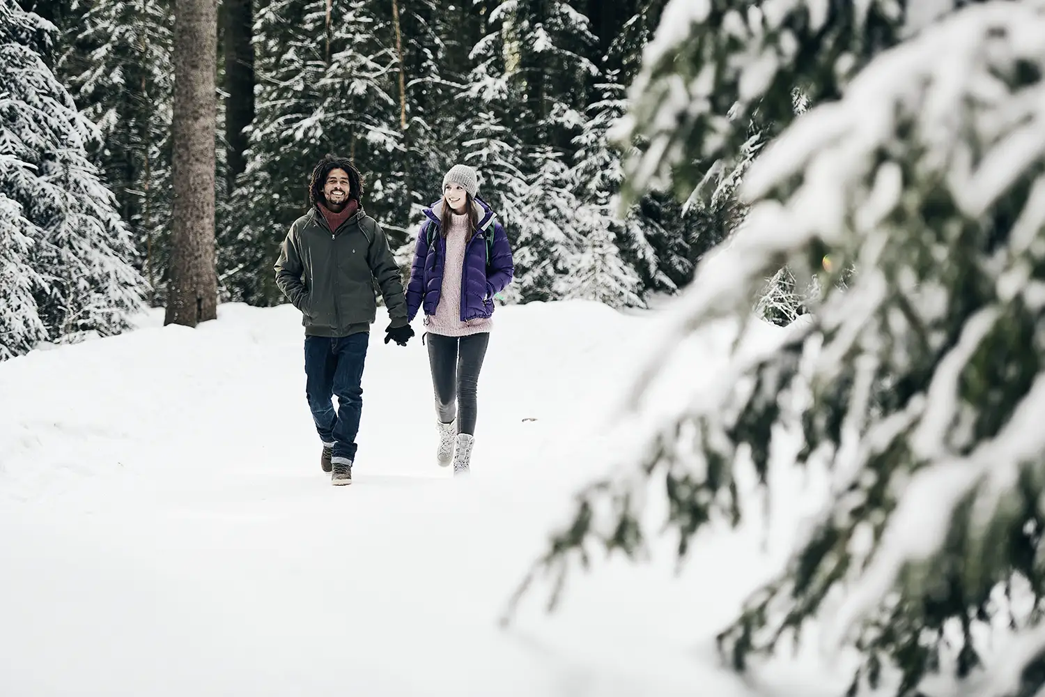 Couple walking in a snow forest