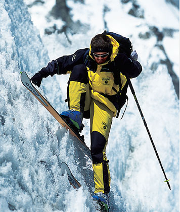 a person in a yellow jacket and skis on a snowy mountain