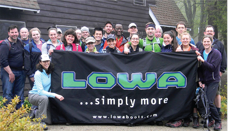 a group of people posing for a photo with a banner