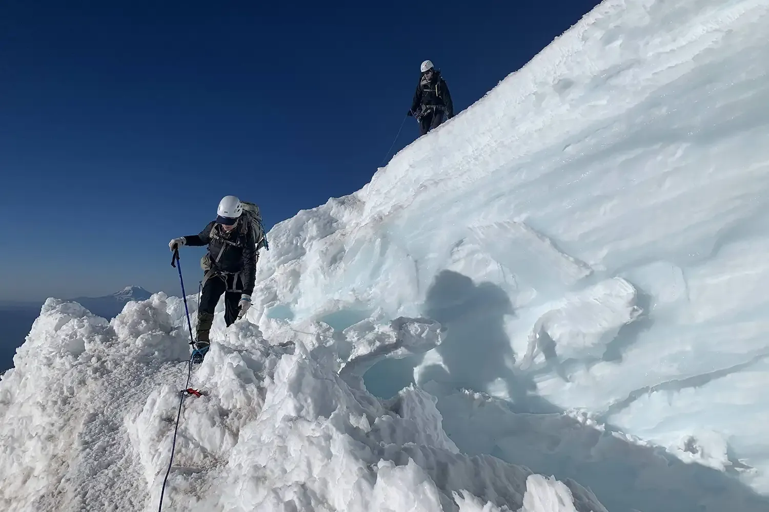 angie's friends shown climbing down a technical snowy mountain