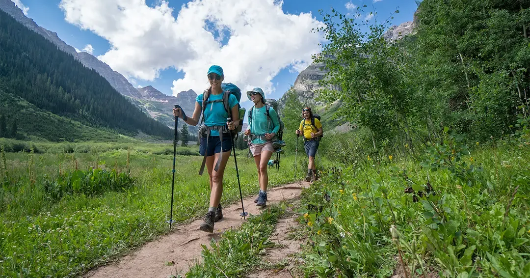three hikers on mountain trail